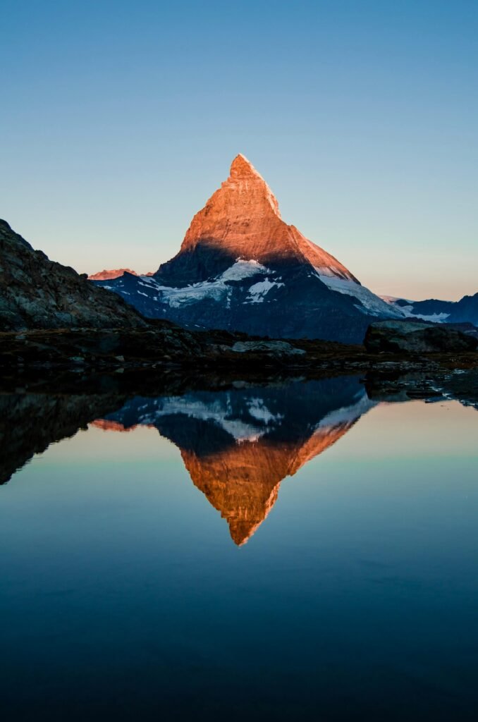 Captivating view of the Matterhorn reflected in a calm lake during sunset, showcasing nature's beauty.